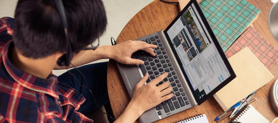 Photo of a male student studying on a laptop