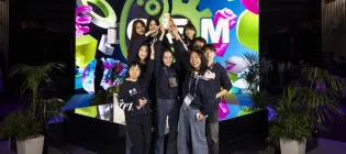 A photo of the winning team on the podium with their trophy