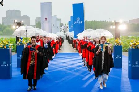 A photo of the ZJE graduates crossing the bridge