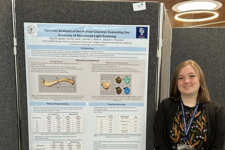 Ellie stands next to her research poster