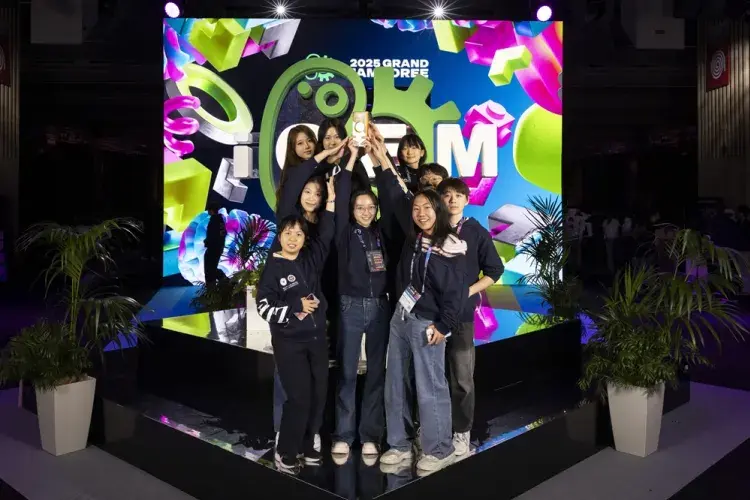 A photo of the winning team on the podium with their trophy