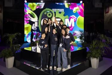 A photo of the winning team on the podium with their trophy