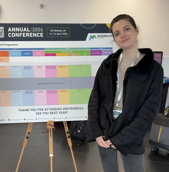 Christiane standing in front of the conference schedule