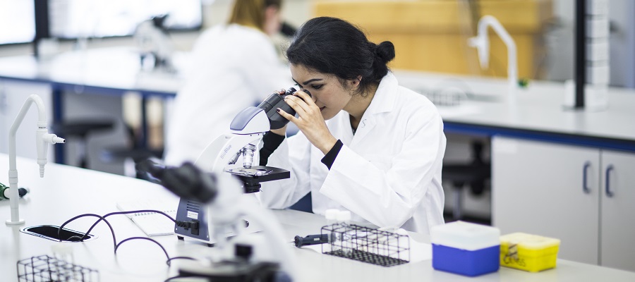 Biomedical researcher with microscope