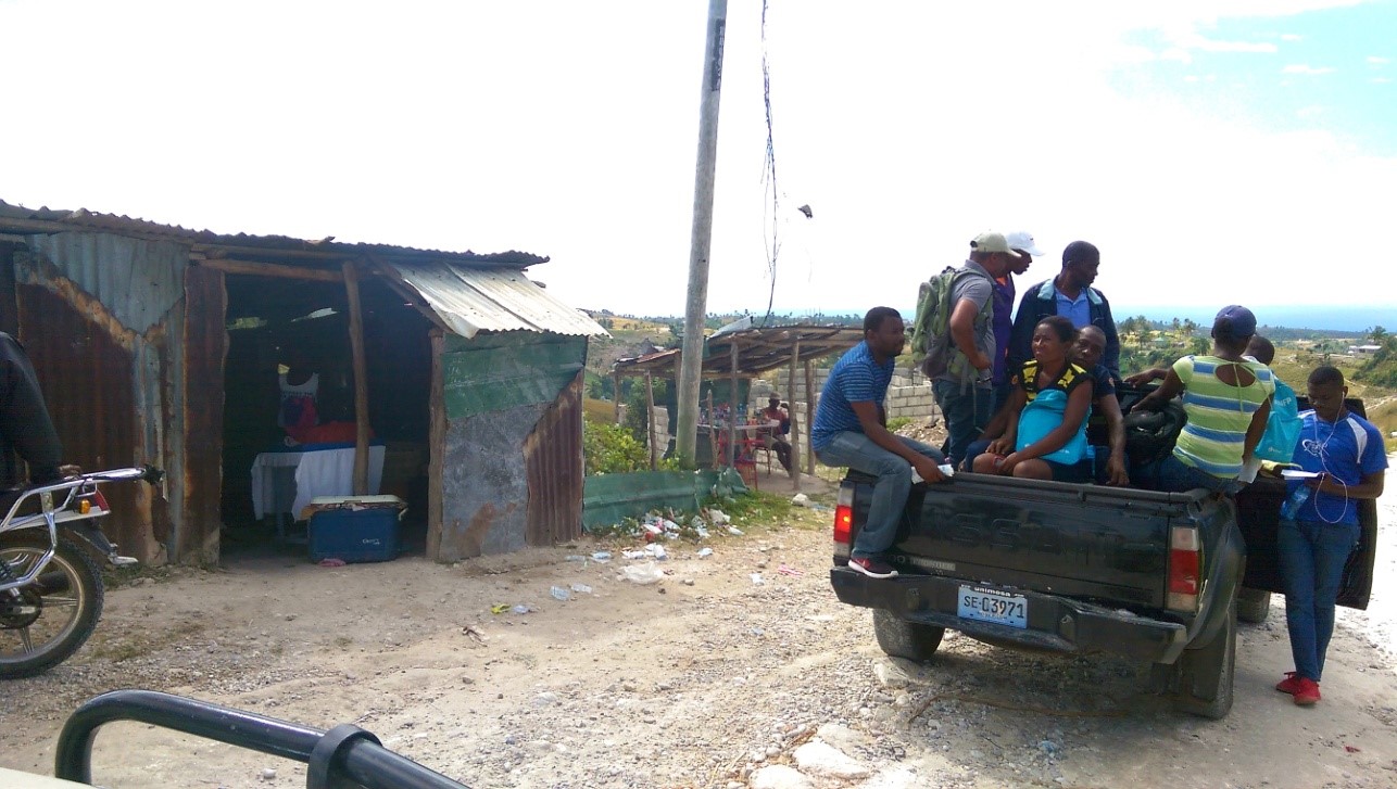 A photograph of a group in the back of a truck on their way to vaccinate dogs, Haiti